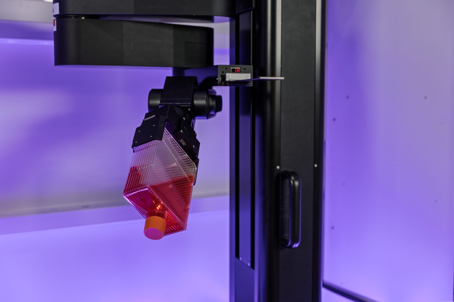 SCARA robot carrying a T-flask inside RoboCell